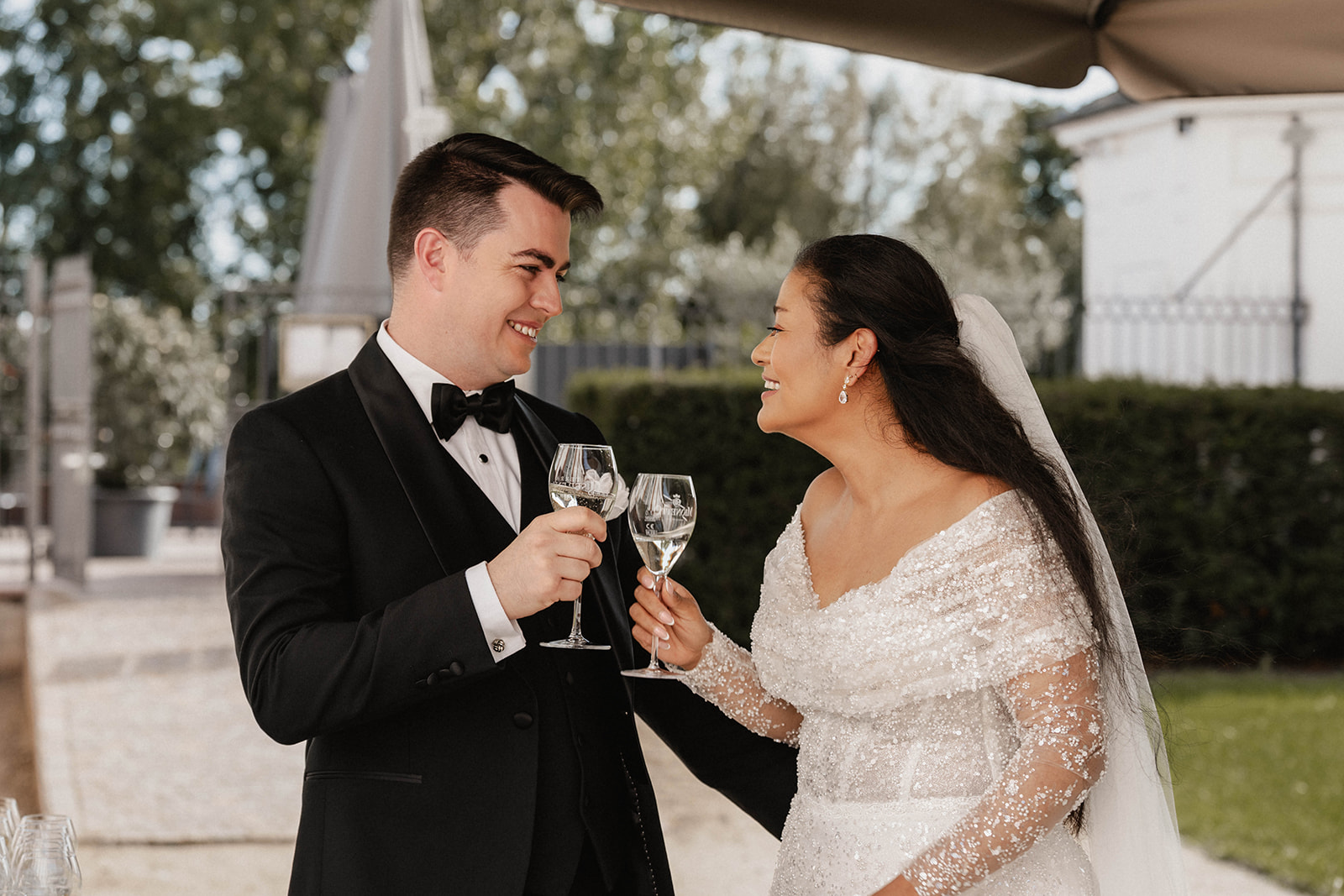 Brautpaar stößt mit Champagner nach der Trauung bei einem Schloss an