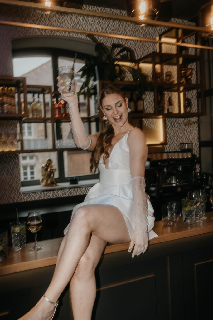 Braut sitzt auf Bartresen